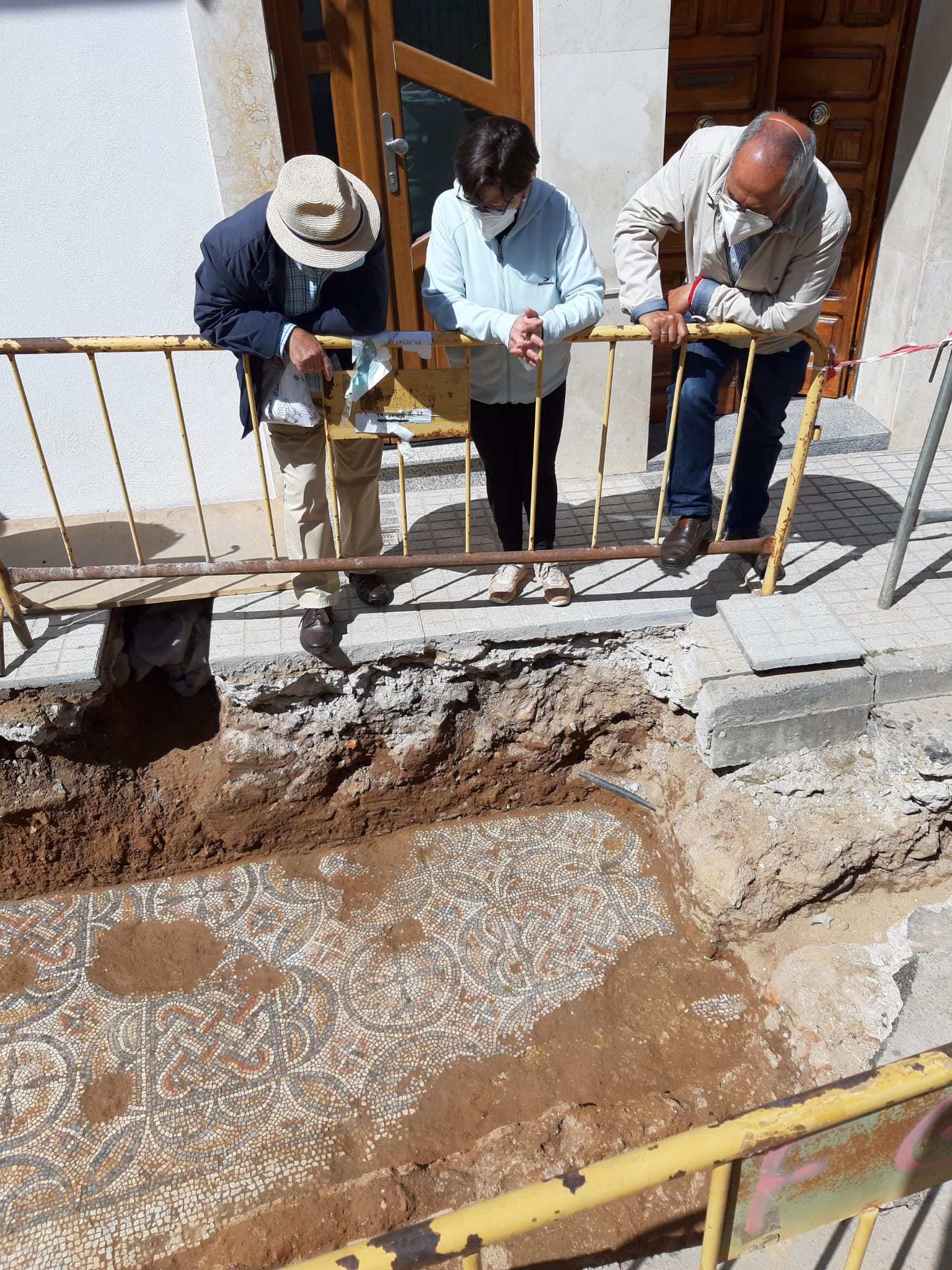 Vecinos de la calle y visitantes observan el mosaico