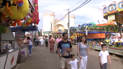 Familia paseando por el recinto ferial durante la Feria de San Juan de Badajoz