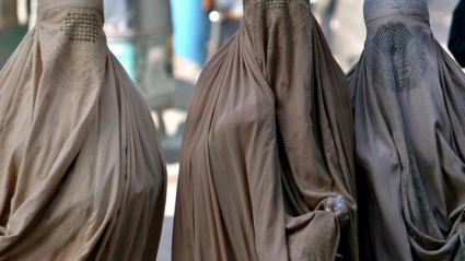 Tres mujeres con burka negro.