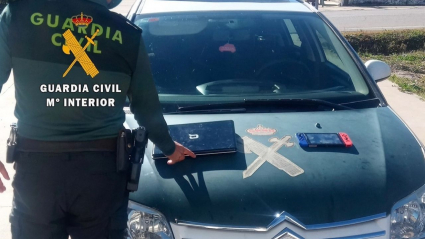 Un agente muestra algunos de los objetos recuperados en la casa y que supuestamente habían sido robados