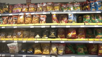Bolsas de patatas en una estantería de supermercado