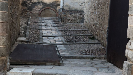 Imagen de la puerta desencajada y tirada en el suelo