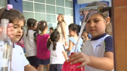 Niña llenando su cantimplora de agua en un colegio extremeño