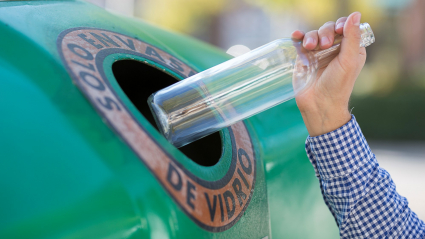 Mujer reciclando vidrio en un contenedor