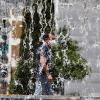 un hombre pasea con mascarilla cerca de una fuente
