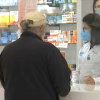 Una farmacéutica atiende a un cliente en una botica de Cáceres