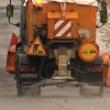 Máquina esparciendo sal contra el hielo en la carretera