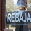 Colocando el cartel de rebajas en una tienda de Plasencia.