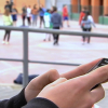 alumno usando móvil en el recreo