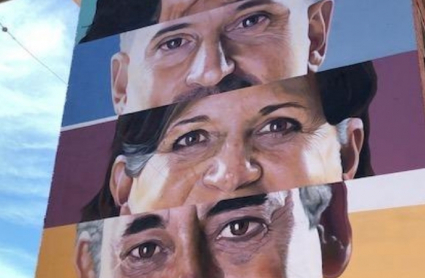 El artista placentino Brea concluye su intervención sobre el muro que representa a 5 placentinos que miran a la pandemia con optimismo.