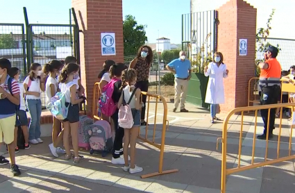 En el colegio Virgen de la Luz de Alconchel, la directora ha dado la bienvenida a padres, madres y alumnos. Escolares esperando para entrar al colegio entre vallas y de forma ordenada.