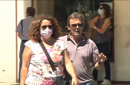 Pareja en la que uno lleva mascarilla en exterior y el otro no