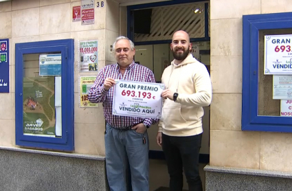 Dueños de la Administración Número 4 de Badajoz mostrando el cartel del premio de la Primitiva