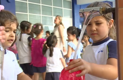 Niña llenando su cantimplora de agua en un colegio extremeño