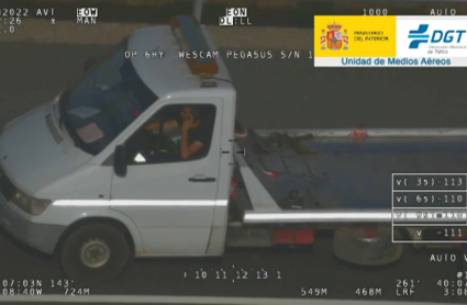 Conductor utilizando el móvil al volante, en una imagen de la DGT.
