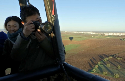 Periodistas chinos desde un globo que sobrevuela olivares en Tierra de Barros